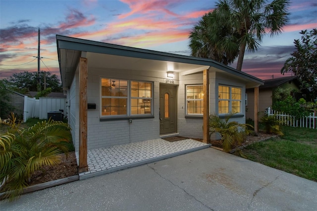 3066 Highland St N, Saint Petersburg, FL 33704 - exterior entry at dusk with central air condition unit and brick siding