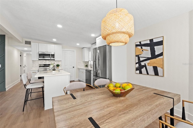 3066 Highland St N, Saint Petersburg, FL 33704 - dining area with light wood finished floors, recessed lighting, and baseboards