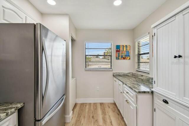 kitchen with white cabinetry, freestanding refrigerator, and plenty of natural light