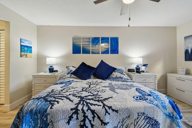 bedroom featuring baseboards, light wood finished floors, and ceiling fan