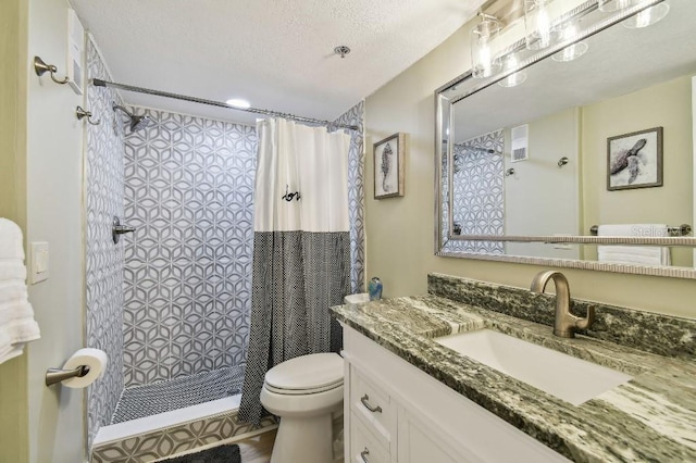full bath with toilet, a textured ceiling, vanity, and a tile shower