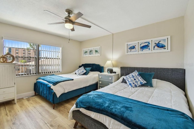 bedroom with baseboards, ceiling fan, and wood finished floors