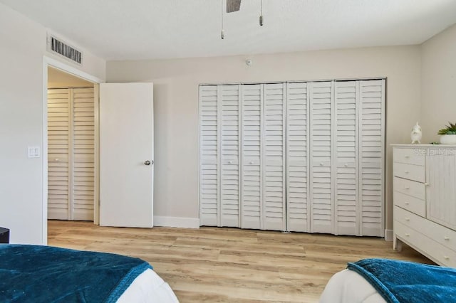 bedroom with visible vents, baseboards, a closet, and wood finished floors