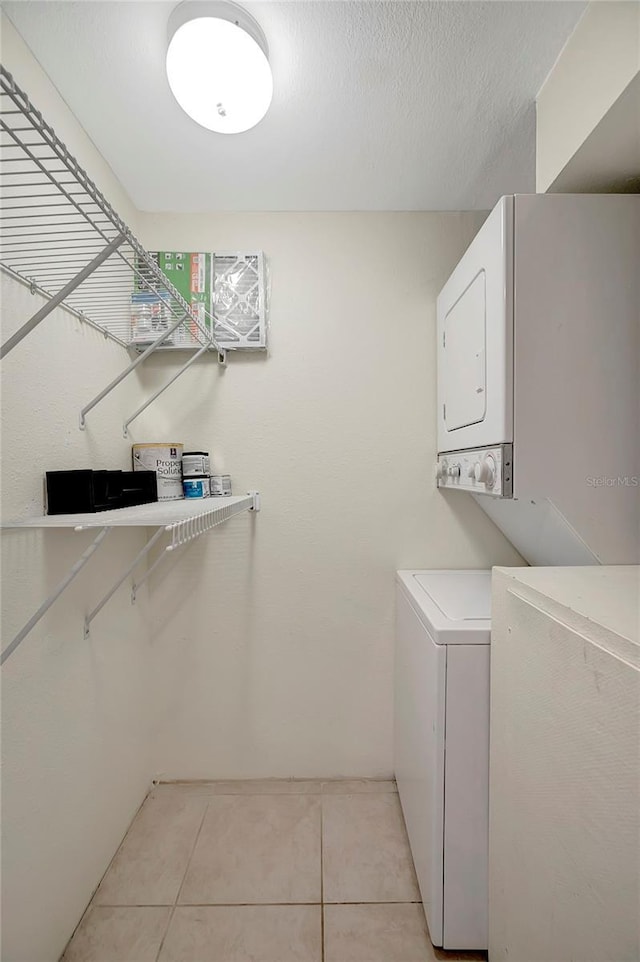 3206 W Azeele St Unit 126, Tampa, FL 33609 - laundry room featuring stacked washer / drying machine and light tile patterned floors