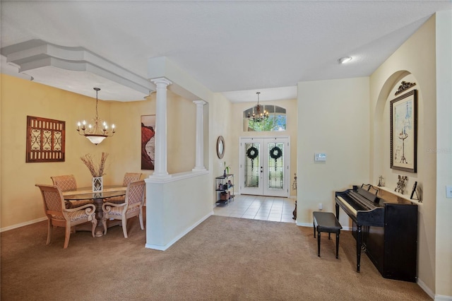 carpeted entryway featuring baseboards, french doors, and a notable chandelier