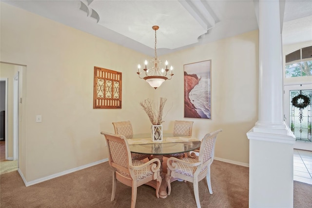 carpeted dining area featuring baseboards, a notable chandelier, and ornate columns