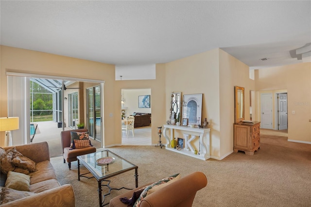 living area with baseboards, a sunroom, a textured ceiling, and light carpet
