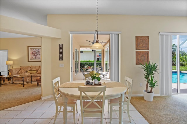 dining area featuring baseboards, light tile patterned floors, and light carpet