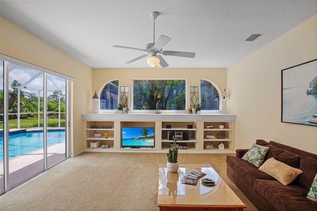 carpeted living area with ceiling fan and visible vents