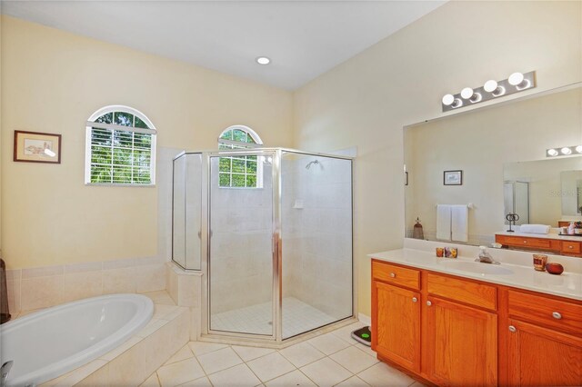 full bathroom with a stall shower, tile patterned flooring, vanity, and a garden tub