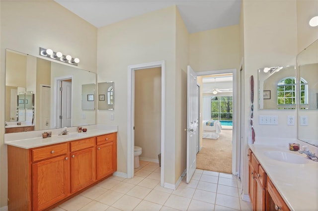 full bath with tile patterned flooring, toilet, a sink, ensuite bath, and two vanities