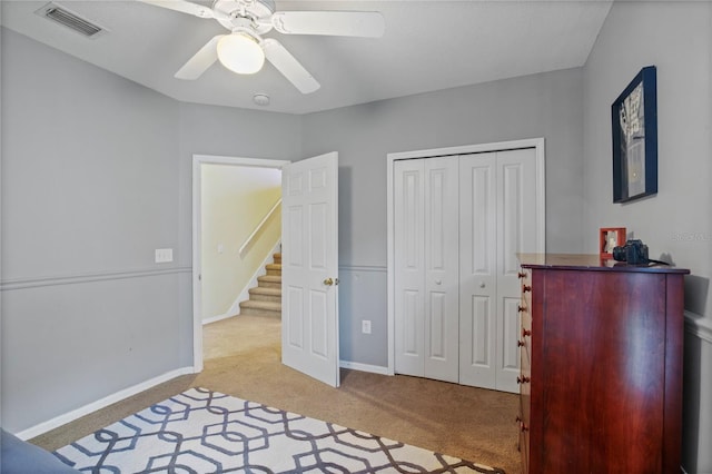 bedroom featuring a closet, a ceiling fan, baseboards, light colored carpet, and visible vents