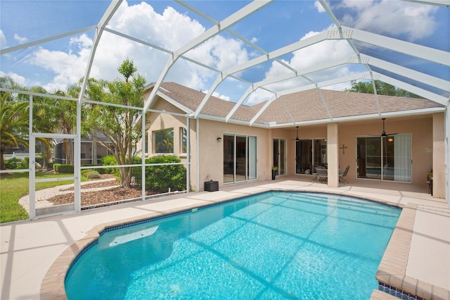 pool with glass enclosure, ceiling fan, and a patio area