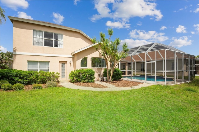 back of house with an outdoor pool, a lanai, stucco siding, and a lawn