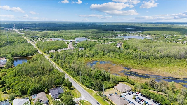 drone / aerial view with a water view and a forest view
