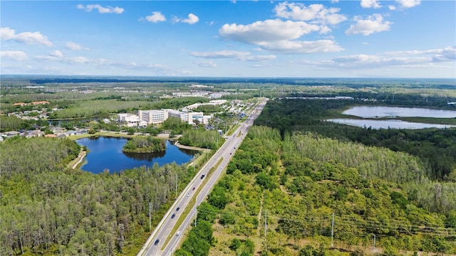 drone / aerial view with a water view and a wooded view