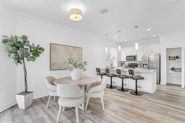 2410 W N A St Unit 2, Tampa, FL 33609 - dining space with light wood-style floors, baseboards, ornamental molding, and visible vents