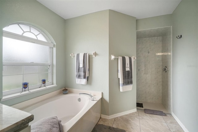 121 Colonial St SW, Port Charlotte, FL 33952 - full bathroom featuring baseboards, a garden tub, a walk in shower, and tile patterned floors