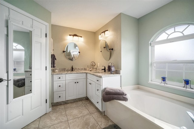 121 Colonial St SW, Port Charlotte, FL 33952 - bathroom featuring tile patterned flooring, vanity, and a garden tub