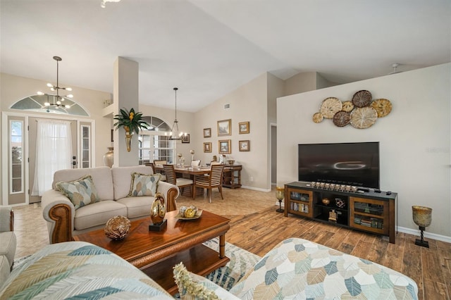 121 Colonial St SW, Port Charlotte, FL 33952 - living area featuring baseboards, a notable chandelier, wood finished floors, and vaulted ceiling
