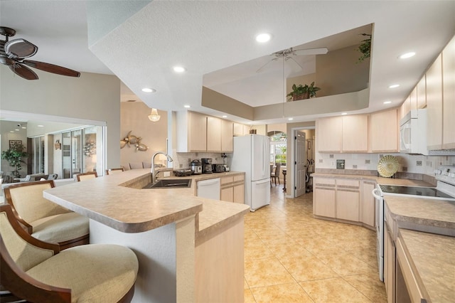 121 Colonial St SW, Port Charlotte, FL 33952 - kitchen featuring a ceiling fan, a peninsula, tasteful backsplash, and white appliances