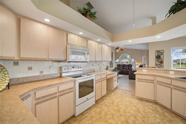 121 Colonial St SW, Port Charlotte, FL 33952 - kitchen featuring white appliances, light countertops, and light brown cabinets