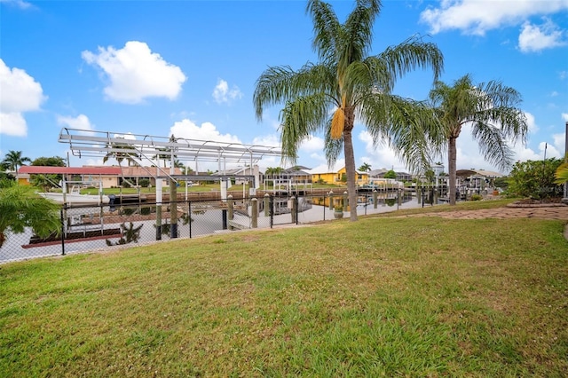 121 Colonial St SW, Port Charlotte, FL 33952 - view of dock with a lawn, a water view, boat lift, and a residential view