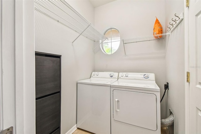 washroom with independent washer and dryer and laundry area