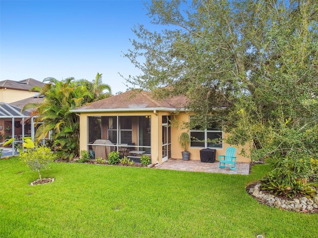 back of house featuring a yard, a patio area, and stucco siding