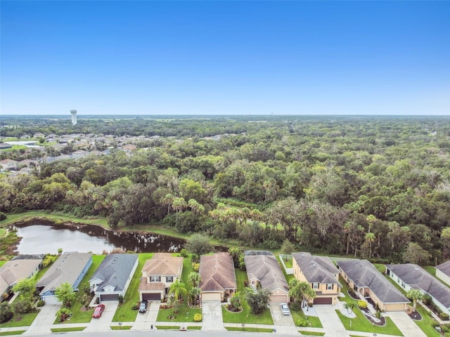 drone / aerial view with a water view, a residential view, and a view of trees