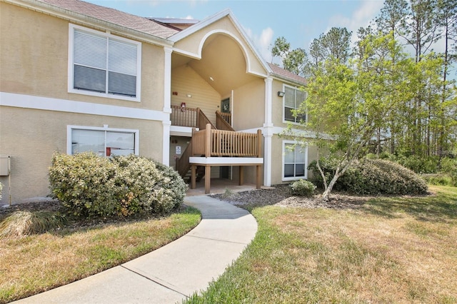 9481 Highland Oak Dr Unit 1616, Tampa, FL 33647 - view of front of property with stucco siding, a front lawn, solar panels, and a balcony