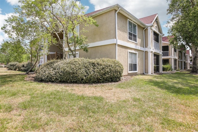 9481 Highland Oak Dr Unit 1616, Tampa, FL 33647 - view of side of home with stucco siding and a lawn