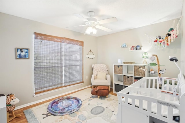 9481 Highland Oak Dr Unit 1616, Tampa, FL 33647 - bedroom with wood finished floors, baseboards, a nursery area, and ceiling fan