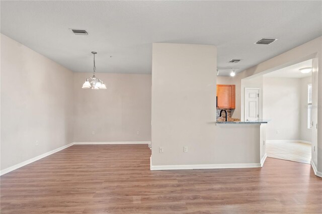 2009 River Turia Cir, Riverview, FL 33578 - spare room with light wood-type flooring, a chandelier, and visible vents