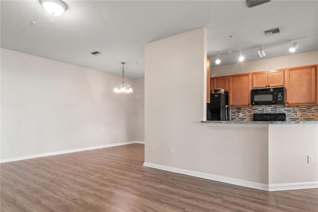 2009 River Turia Cir, Riverview, FL 33578 - kitchen with visible vents, wood finished floors, black appliances, and an inviting chandelier