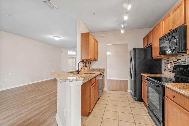 2009 River Turia Cir, Riverview, FL 33578 - kitchen with a sink, a peninsula, baseboards, tasteful backsplash, and black appliances