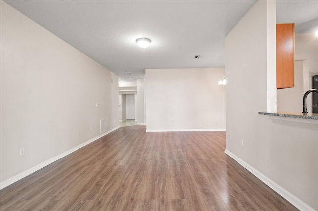 2009 River Turia Cir, Riverview, FL 33578 - unfurnished living room featuring baseboards, visible vents, and wood finished floors