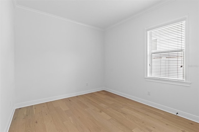 unfurnished room with light wood-style floors, crown molding, and baseboards