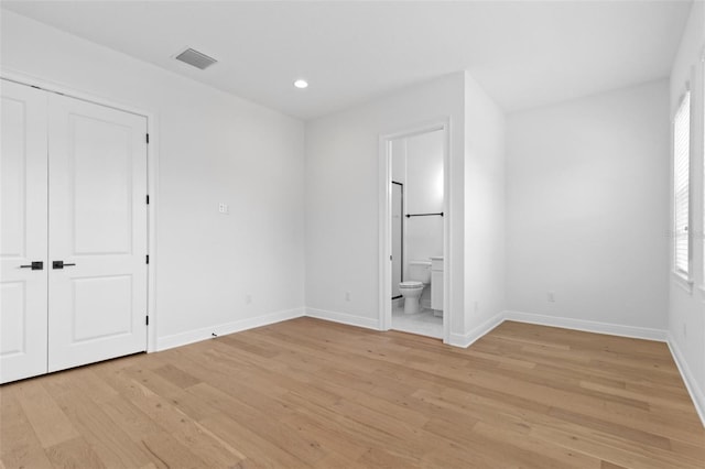 unfurnished bedroom with light wood-style floors, baseboards, recessed lighting, connected bathroom, and a closet