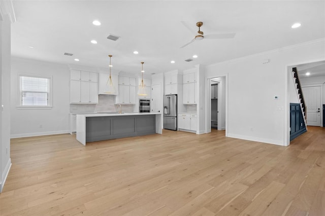 kitchen featuring high end fridge, ornamental molding, baseboards, light countertops, and white cabinetry