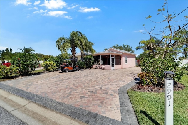 view of front of home with stucco siding and a sunroom
