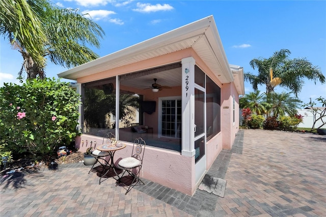 view of patio / terrace with a sunroom and a ceiling fan