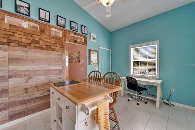 office with vaulted ceiling, a ceiling fan, baseboards, and light tile patterned floors
