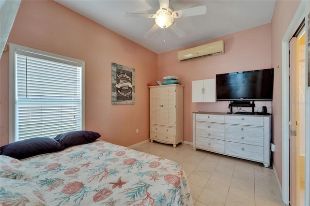 bedroom featuring a wall mounted air conditioner, baseboards, a ceiling fan, and light tile patterned floors