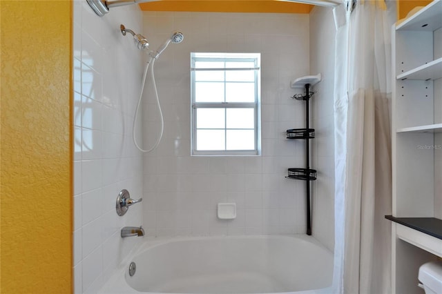 bathroom featuring a textured wall and shower / bath combo