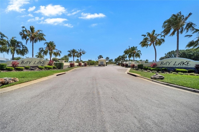 view of street with a gated entry and curbs