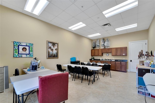 dining space with a drop ceiling, visible vents, and light tile patterned floors