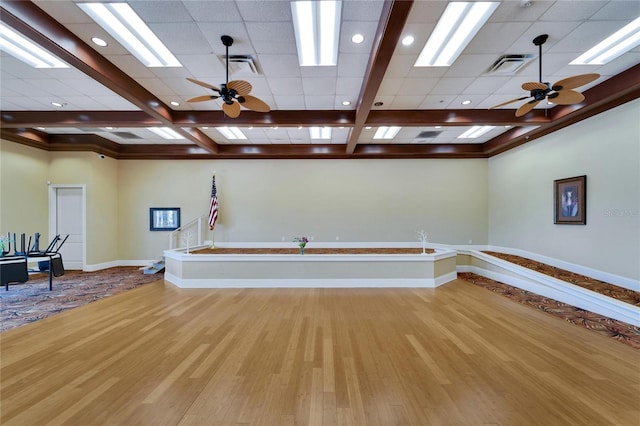 interior space featuring visible vents, a ceiling fan, wood finished floors, and beam ceiling