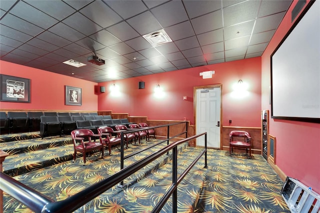 carpeted home theater featuring visible vents and a drop ceiling