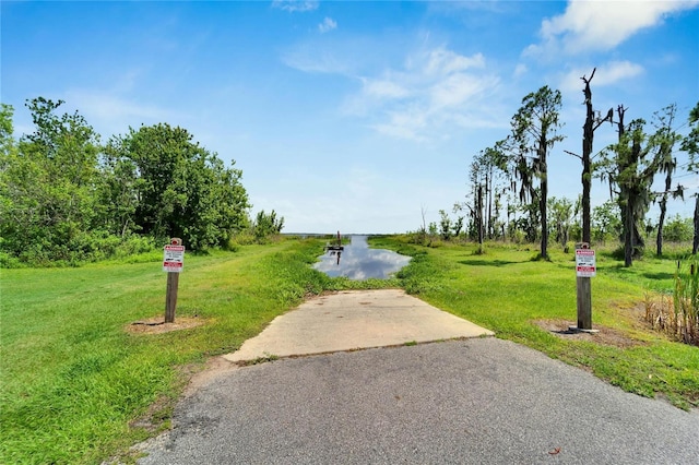 view of property's community with a lawn and a water view
